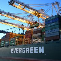 An Evergreen container ship loading at the Port of Baltimore during daytime.